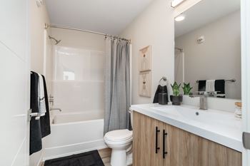 A bathroom with a white toilet, a white sink, and a white bathtub.